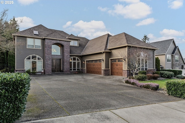 view of front of house featuring a shingled roof, brick siding, driveway, and an attached garage