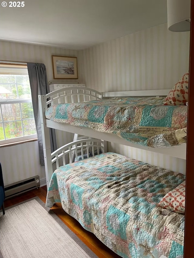 554 N Beacon St, Rockaway Beach, OR 97136 - bedroom featuring baseboard heating and wood finished floors