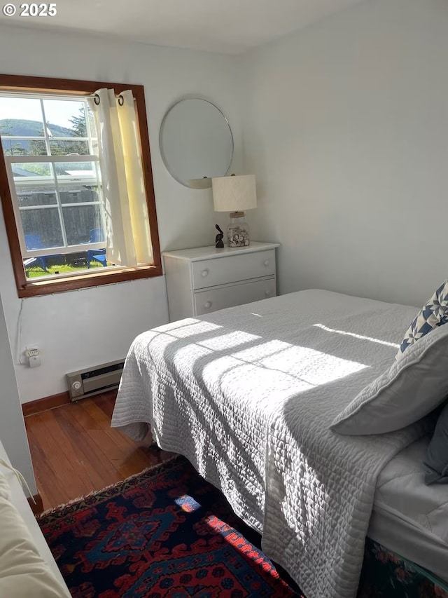 554 N Beacon St, Rockaway Beach, OR 97136 - bedroom with wood finished floors and baseboard heating