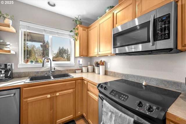 kitchen featuring appliances with stainless steel finishes, light countertops, and a sink