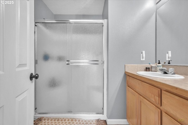 full bathroom with a stall shower and vanity