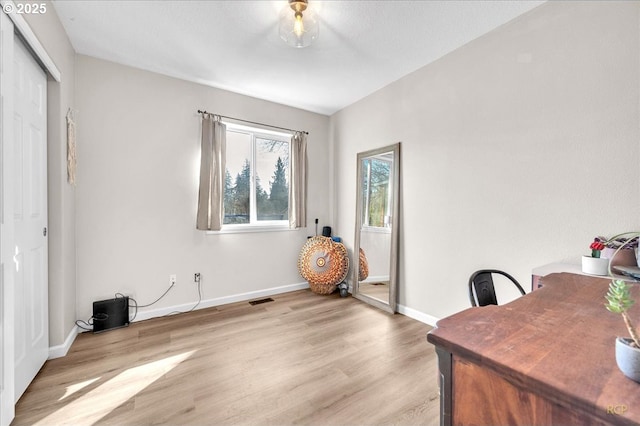 home office with light wood finished floors, baseboards, and visible vents