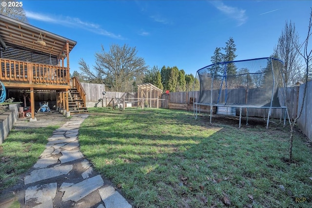 view of yard featuring a fenced backyard, a trampoline, stairway, and a wooden deck