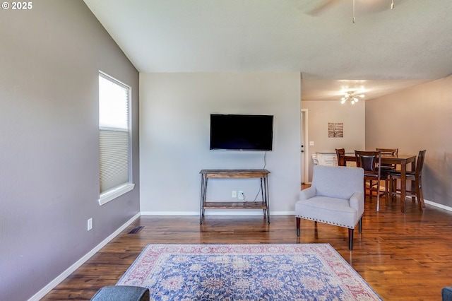 living area featuring a ceiling fan, wood finished floors, and baseboards