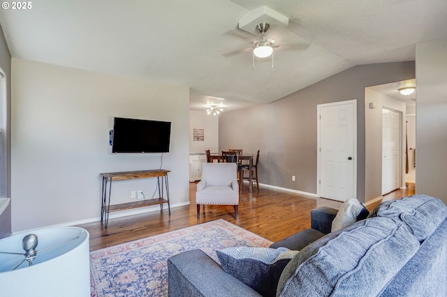 living room with wood finished floors, ceiling fan, lofted ceiling, and baseboards