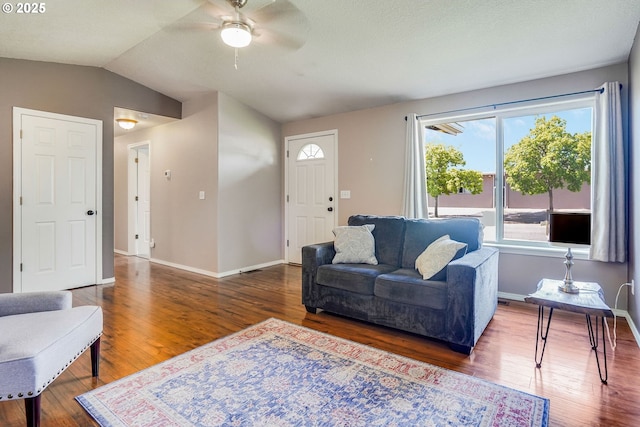 living area featuring ceiling fan, wood finished floors, vaulted ceiling, and baseboards