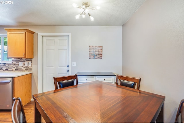 dining area with a textured ceiling, light wood finished floors, a desk, and a chandelier