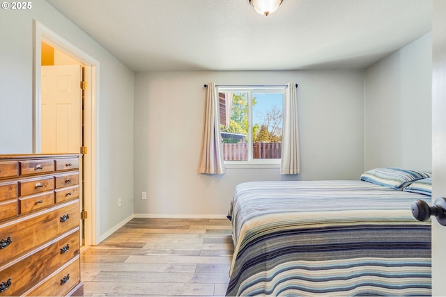 bedroom with light wood-style floors and baseboards