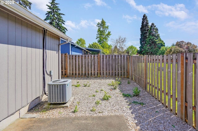 fenced backyard featuring central AC