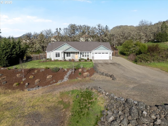 ranch-style home with an attached garage, fence, driveway, and a front lawn