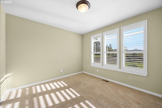 empty room with visible vents, baseboards, and carpet floors