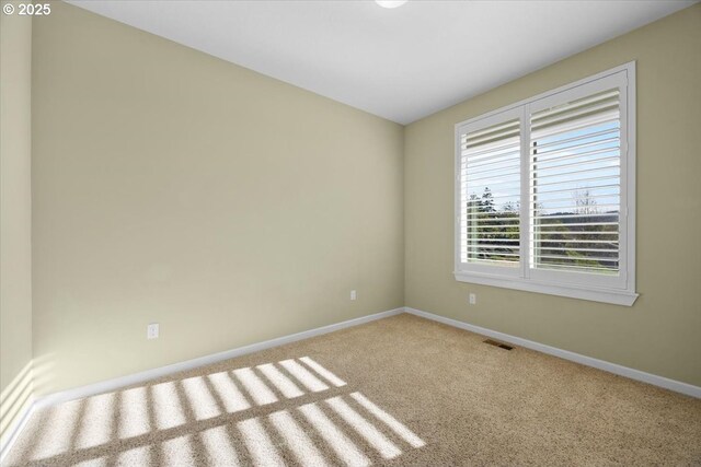 unfurnished room featuring carpet and baseboards