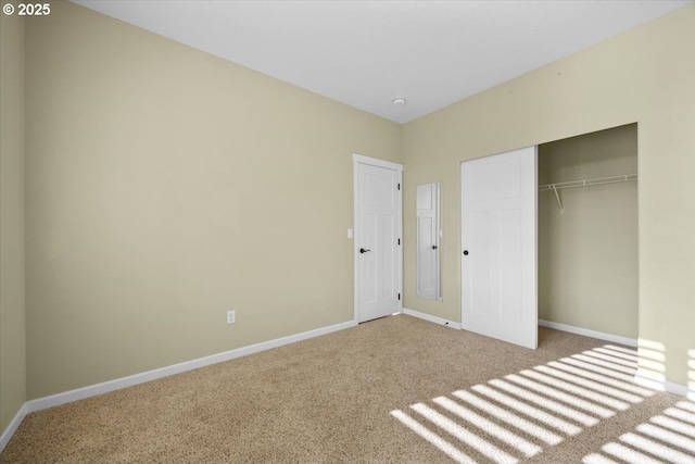 unfurnished bedroom with a closet, baseboards, and carpet flooring