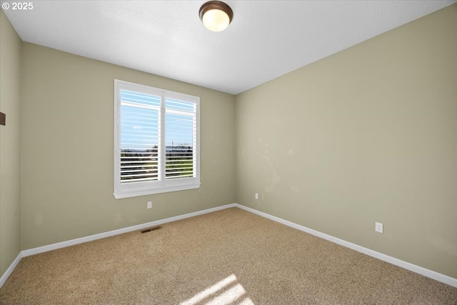carpeted empty room featuring baseboards and visible vents