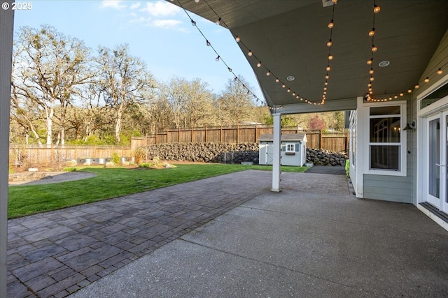 view of patio with a fenced backyard, an outdoor structure, and a storage unit