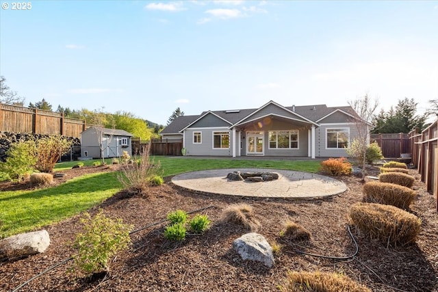 back of property with a fire pit, a storage shed, a lawn, a fenced backyard, and an outdoor structure