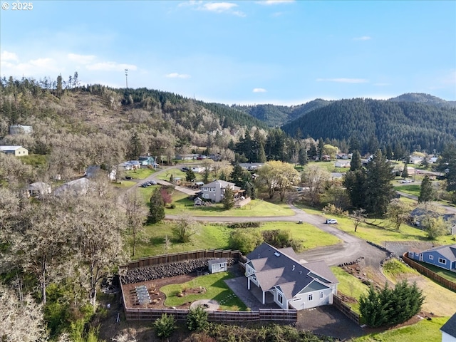 drone / aerial view featuring a wooded view and a mountain view