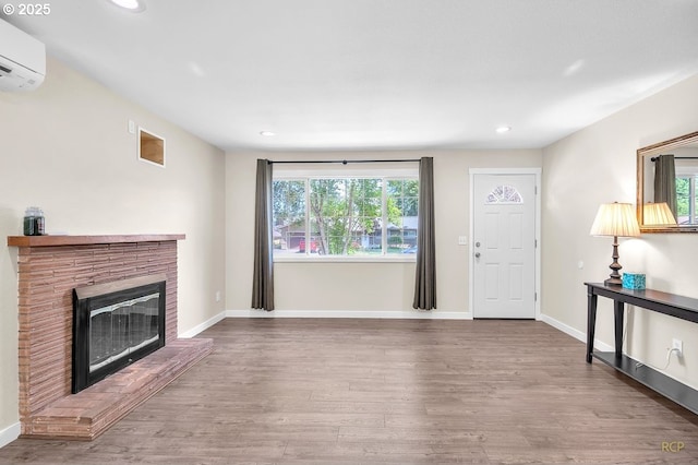 10105 NE 59th St, Vancouver, WA 98662 - unfurnished living room featuring wood finished floors, plenty of natural light, a fireplace, a wall mounted AC, and recessed lighting