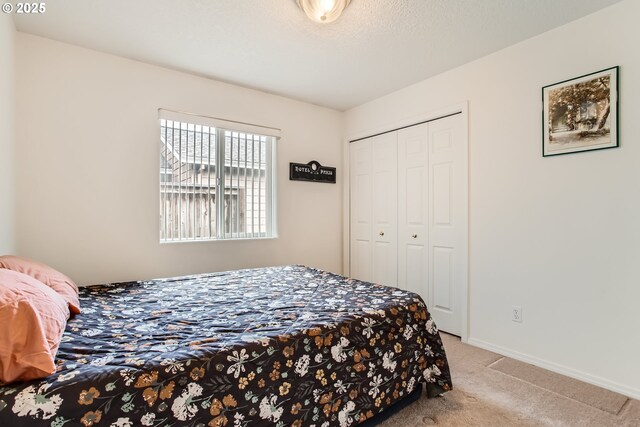 bedroom featuring light colored carpet and a closet