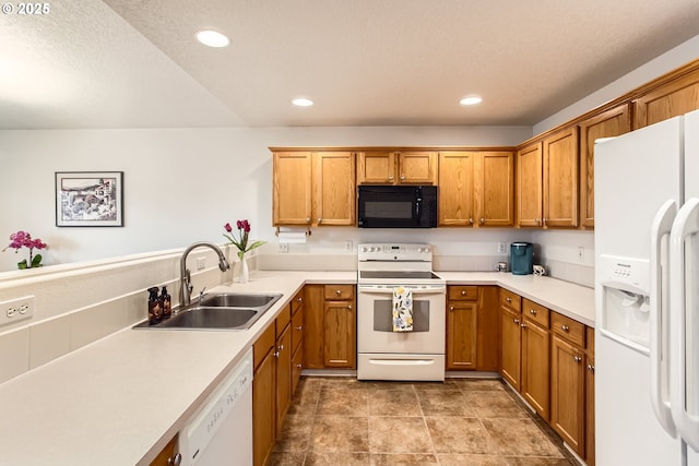 kitchen with white appliances, sink, and a textured ceiling