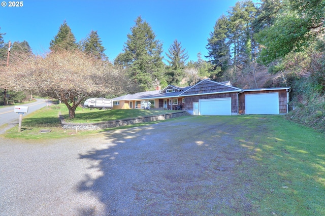 ranch-style house featuring a garage, driveway, and a front lawn