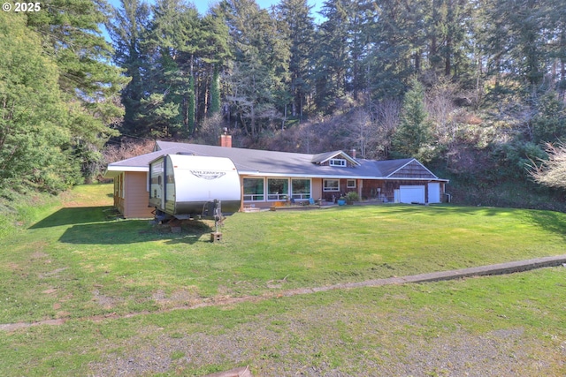 ranch-style house with a garage, a chimney, and a front lawn