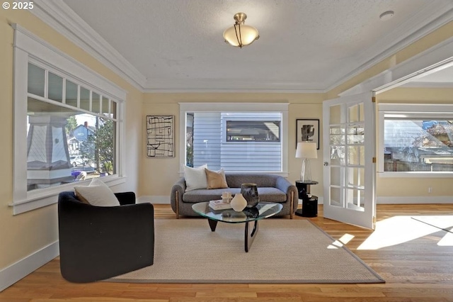 living room featuring french doors, crown molding, baseboards, and wood finished floors