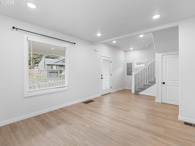 foyer with electric panel and light hardwood / wood-style floors