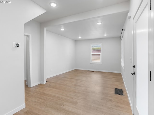 empty room featuring a barn door and light wood-type flooring