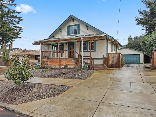 view of front of property featuring covered porch, a garage, and an outdoor structure