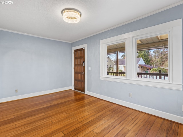 spare room featuring ornamental molding and hardwood / wood-style floors