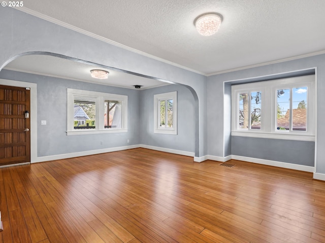 interior space featuring hardwood / wood-style flooring, a textured ceiling, and ornamental molding