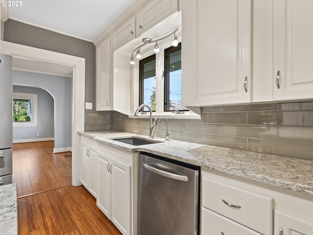 kitchen with sink, stainless steel appliances, white cabinetry, and backsplash