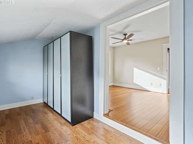 interior space with wood-type flooring, a textured ceiling, ceiling fan, and vaulted ceiling