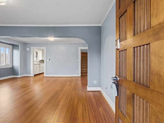 unfurnished room with ornamental molding and light wood-type flooring