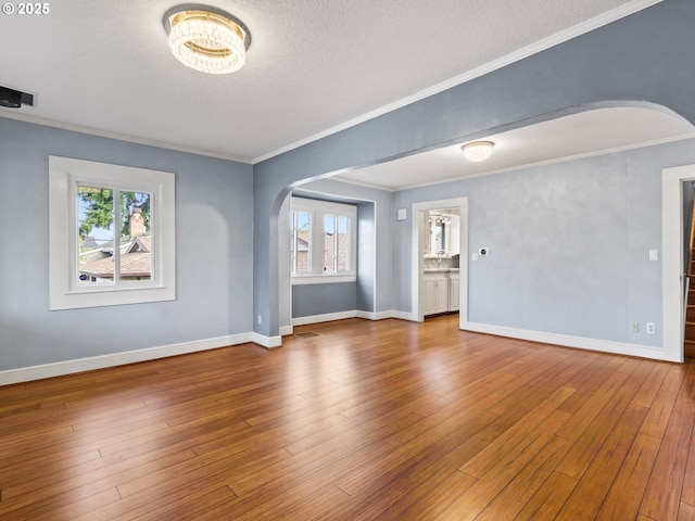 unfurnished room with hardwood / wood-style floors, ornamental molding, and plenty of natural light