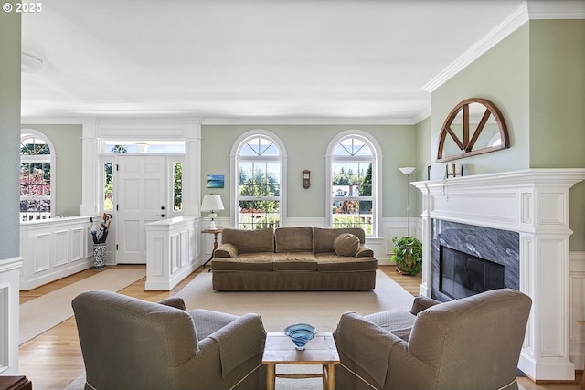 1221 SW Forest Meadows Way, Lake Oswego, OR 97034 - living room featuring crown molding, a high end fireplace, light wood-style flooring, wainscoting, and a decorative wall