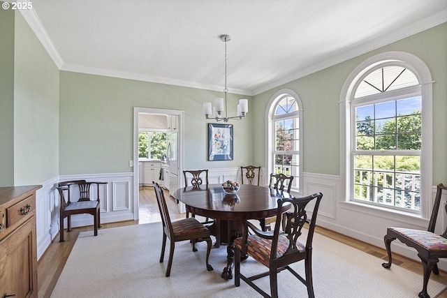 1221 SW Forest Meadows Way, Lake Oswego, OR 97034 - dining area with light wood finished floors, ornamental molding, a chandelier, and wainscoting