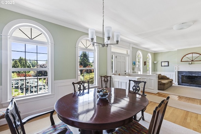 1221 SW Forest Meadows Way, Lake Oswego, OR 97034 - dining room with a chandelier, light wood finished floors, a wainscoted wall, a premium fireplace, and ornamental molding