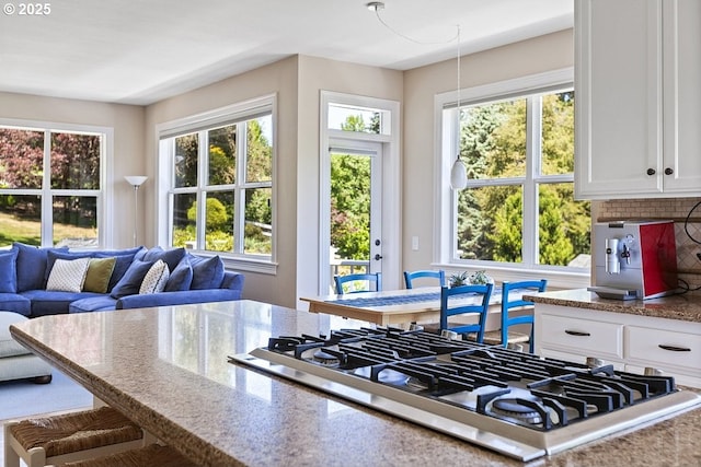 1221 SW Forest Meadows Way, Lake Oswego, OR 97034 - kitchen featuring stainless steel gas stovetop, white cabinets, light stone counters, backsplash, and open floor plan