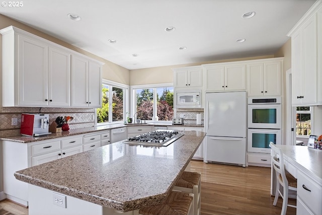 1221 SW Forest Meadows Way, Lake Oswego, OR 97034 - kitchen with white appliances, decorative backsplash, white cabinetry, light wood finished floors, and recessed lighting