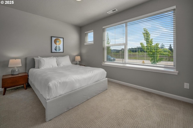carpeted bedroom featuring baseboards and visible vents