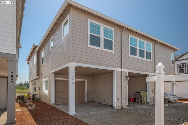 view of front of property featuring central air condition unit, an attached garage, and concrete driveway