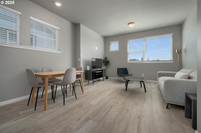 dining area with light wood-style floors and baseboards