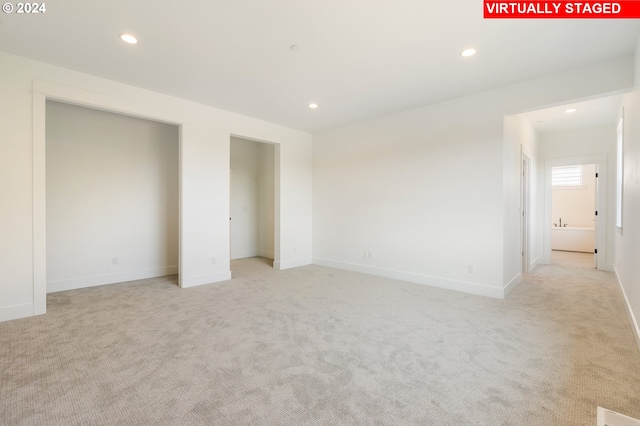 unfurnished bedroom with recessed lighting, light colored carpet, and baseboards