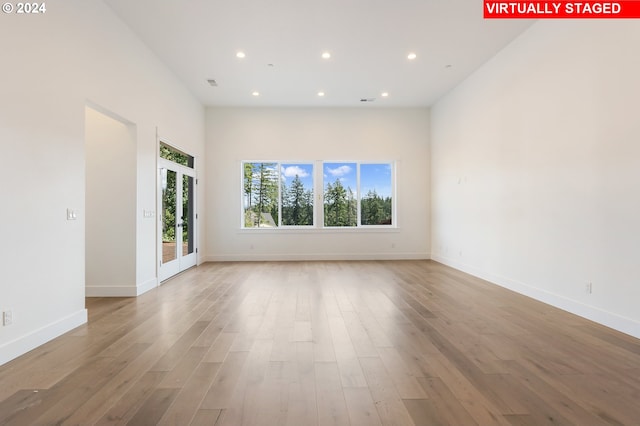 unfurnished room with light wood-type flooring, visible vents, baseboards, and recessed lighting