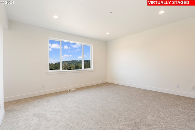 empty room featuring recessed lighting, light carpet, visible vents, and baseboards