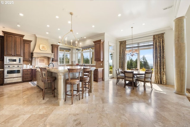 12955 NW Skyline Blvd, Portland, OR 97231 - kitchen featuring oven, built in microwave, ornamental molding, premium range hood, and a spacious island