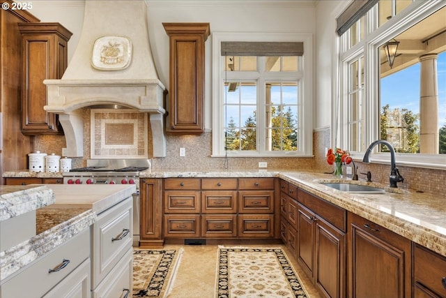12955 NW Skyline Blvd, Portland, OR 97231 - kitchen featuring a sink, custom range hood, brown cabinetry, decorative backsplash, and inlaid floor details