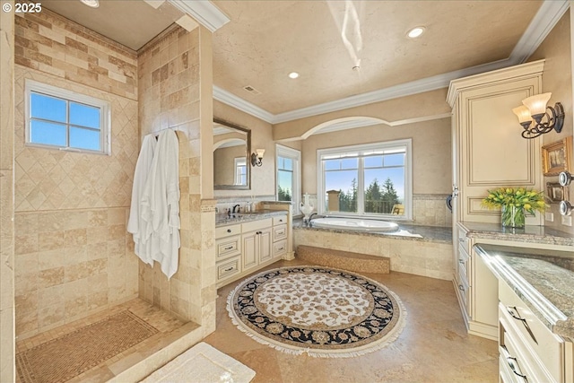 bathroom with crown molding, vanity, and tiled bath